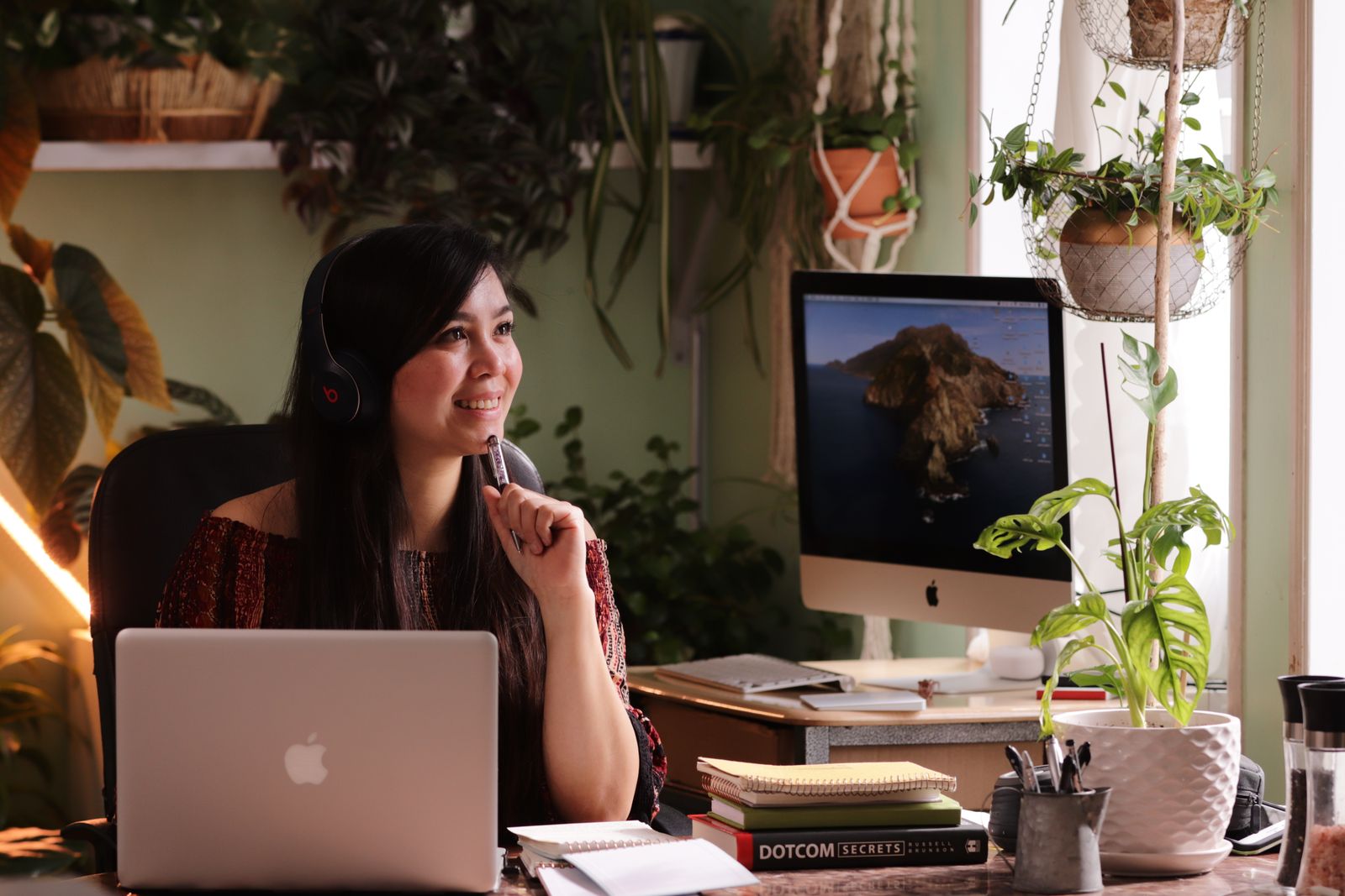 Remote worker wearing headphones and taking notes at a computer in a London home office